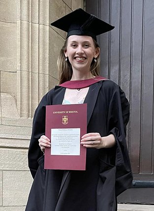 girl in graduation gown holding programme